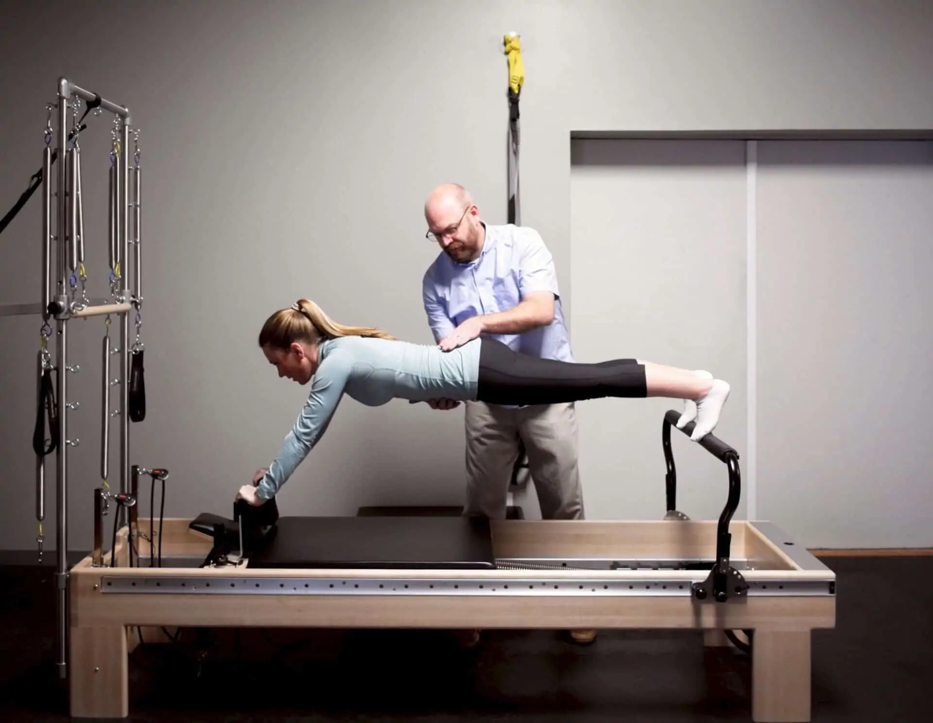 Doctor of physical therapy using pilates reformer to help improve posture and core stability.